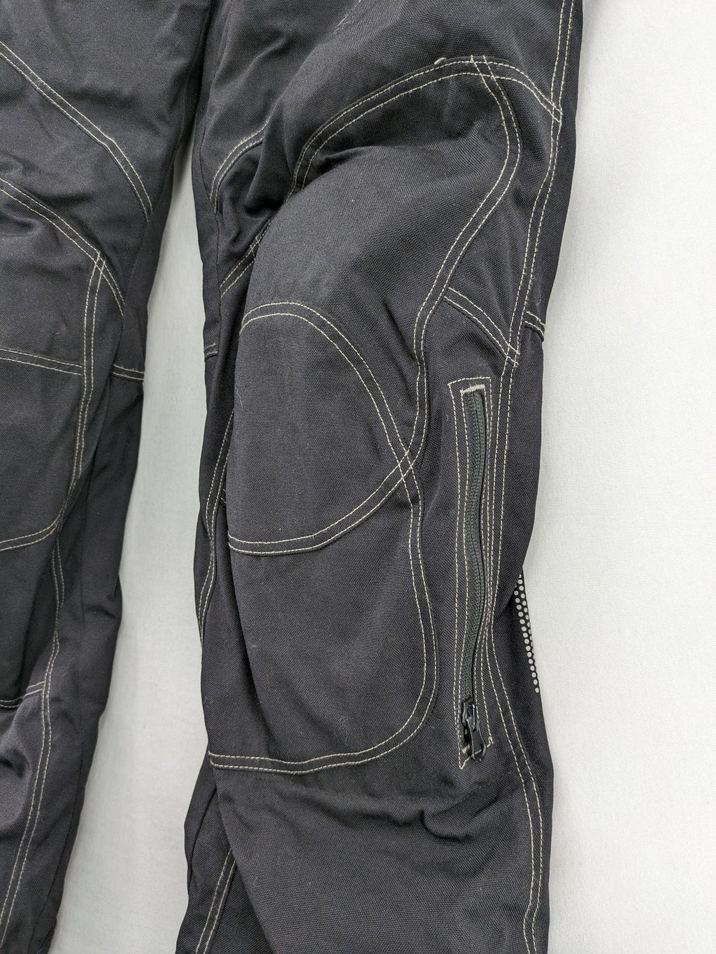 Rukka black motorcycle chaps with grey accents and CE knee protectors, made from durable Cordura.