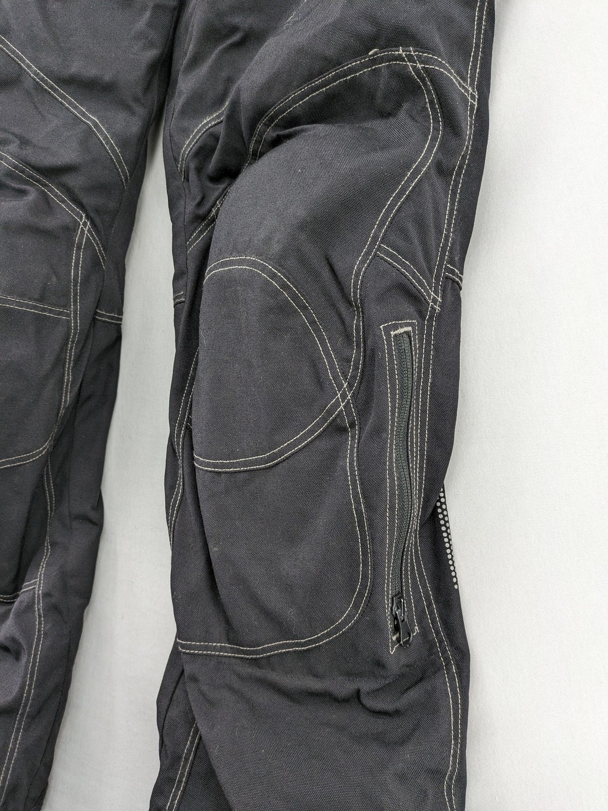 Rukka black motorcycle chaps with grey accents and CE knee protectors, made from durable Cordura.