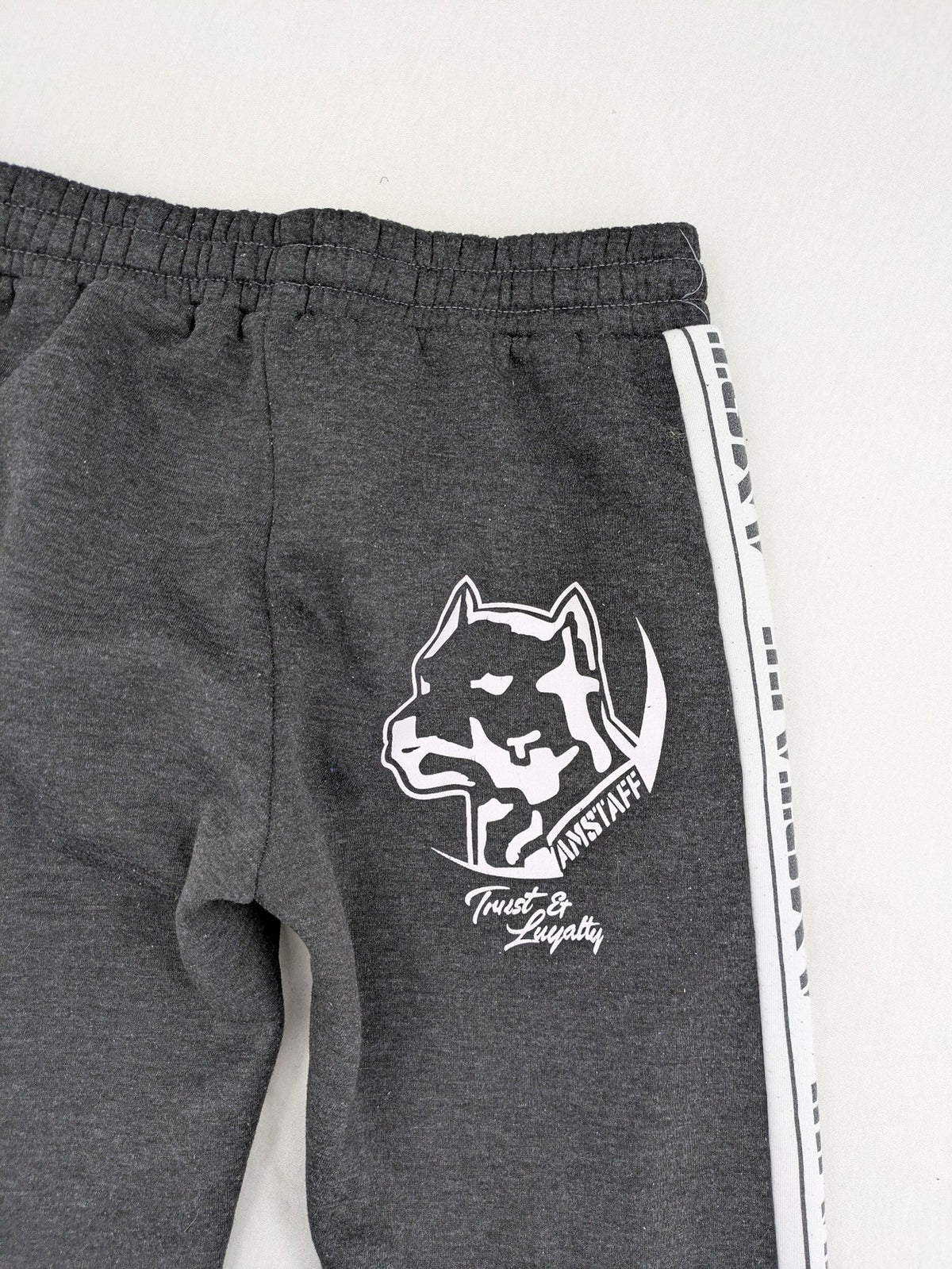 Amstaff grey sweatpants with large dog logo and "Trust & Loyalty" text.
