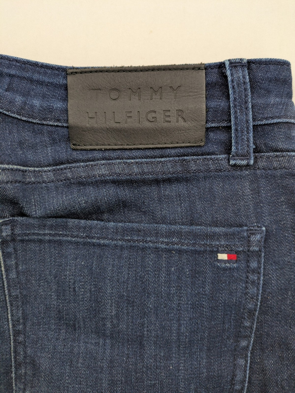 Tommy Hilfiger blue straight jeans with iconic logo and dark wash denim finish.