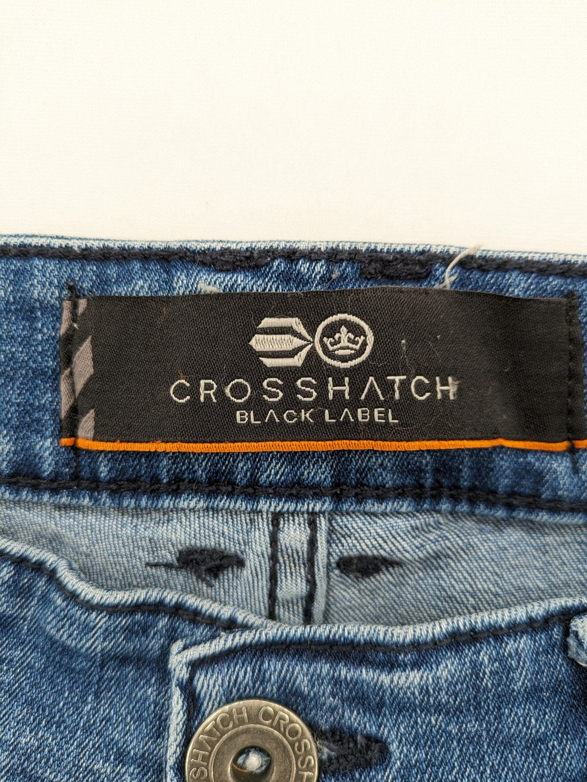 Crosshatch blue slim fit jeans with faded wash and logo patch on back pocket.