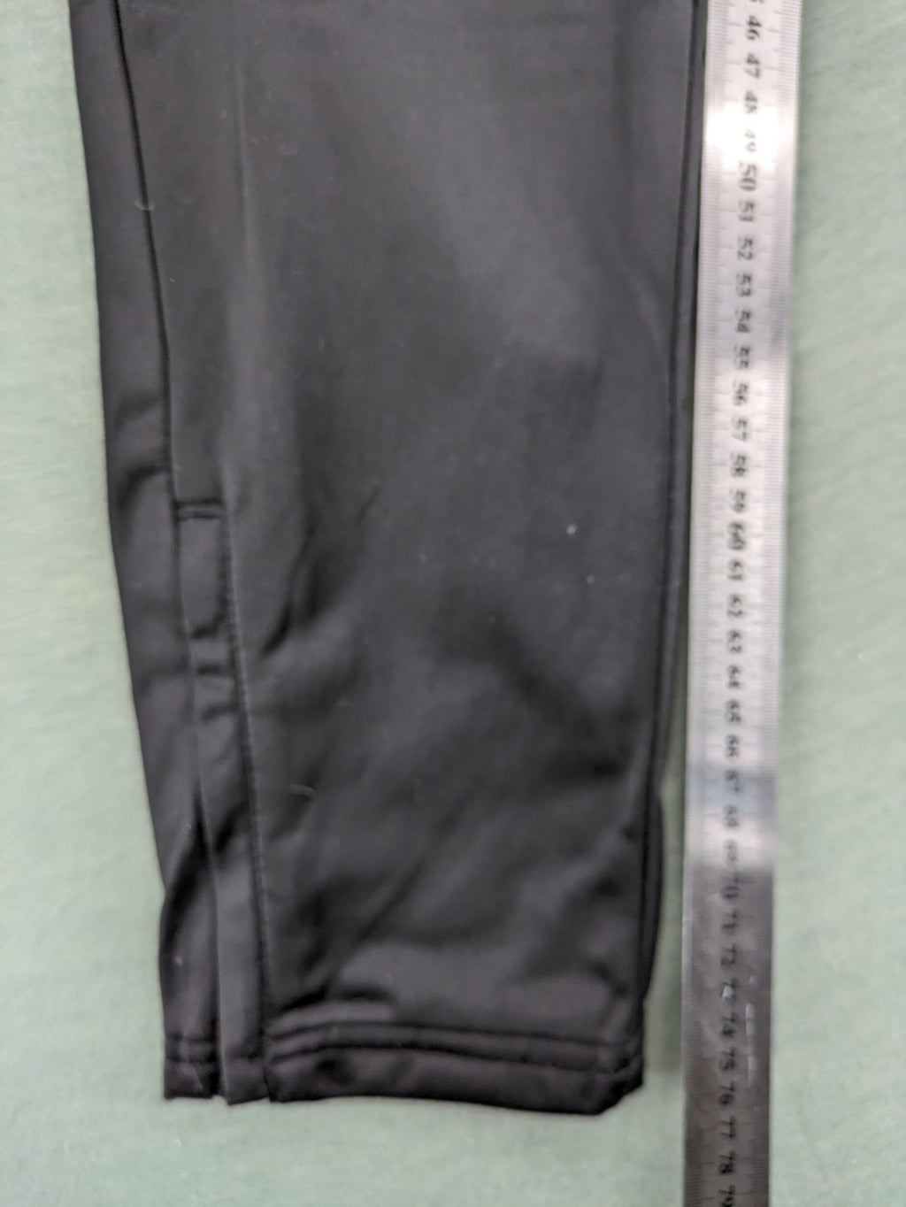 Crivit black weighted training pants with elastic waistband, side pockets, and zippered cuffs.