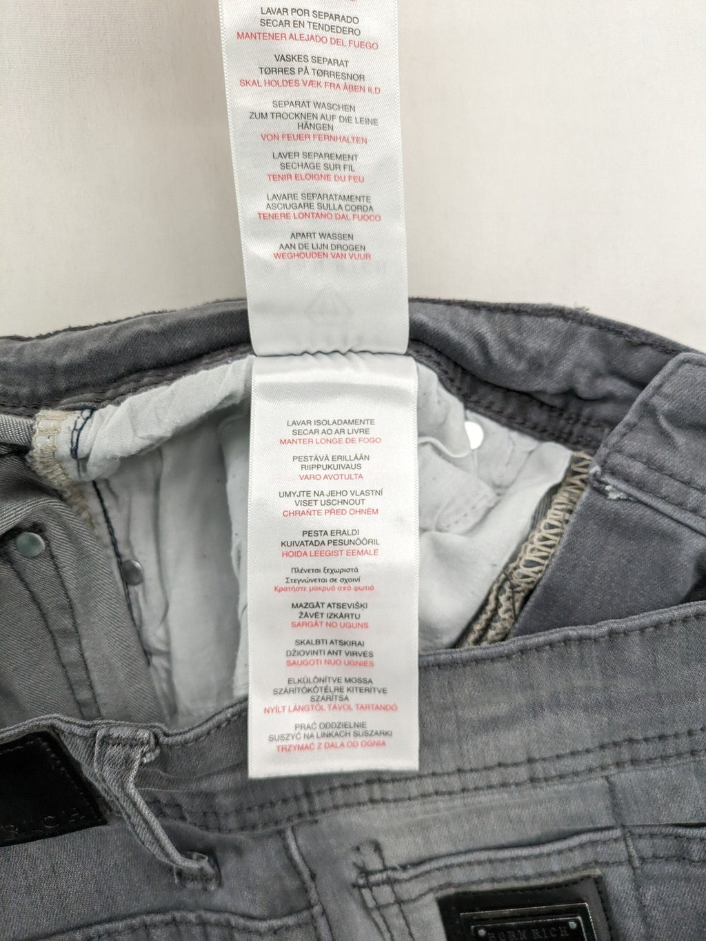 Born Rich grey slim fit jeans with button fly and washed denim texture.