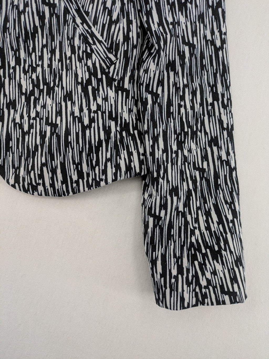 H&M Divided black and white patterned blazer with open front and two front pockets.