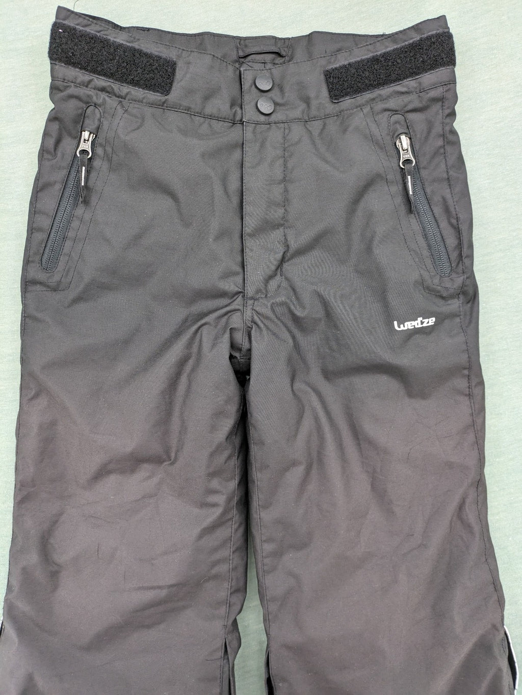Wed'ze black ski pants with adjustable waistband, zip pockets, and Pull'n'Fit system.