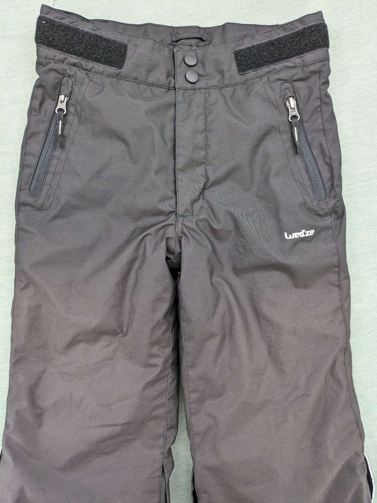 Wed'ze black ski pants with adjustable waistband, zip pockets, and Pull'n'Fit system.