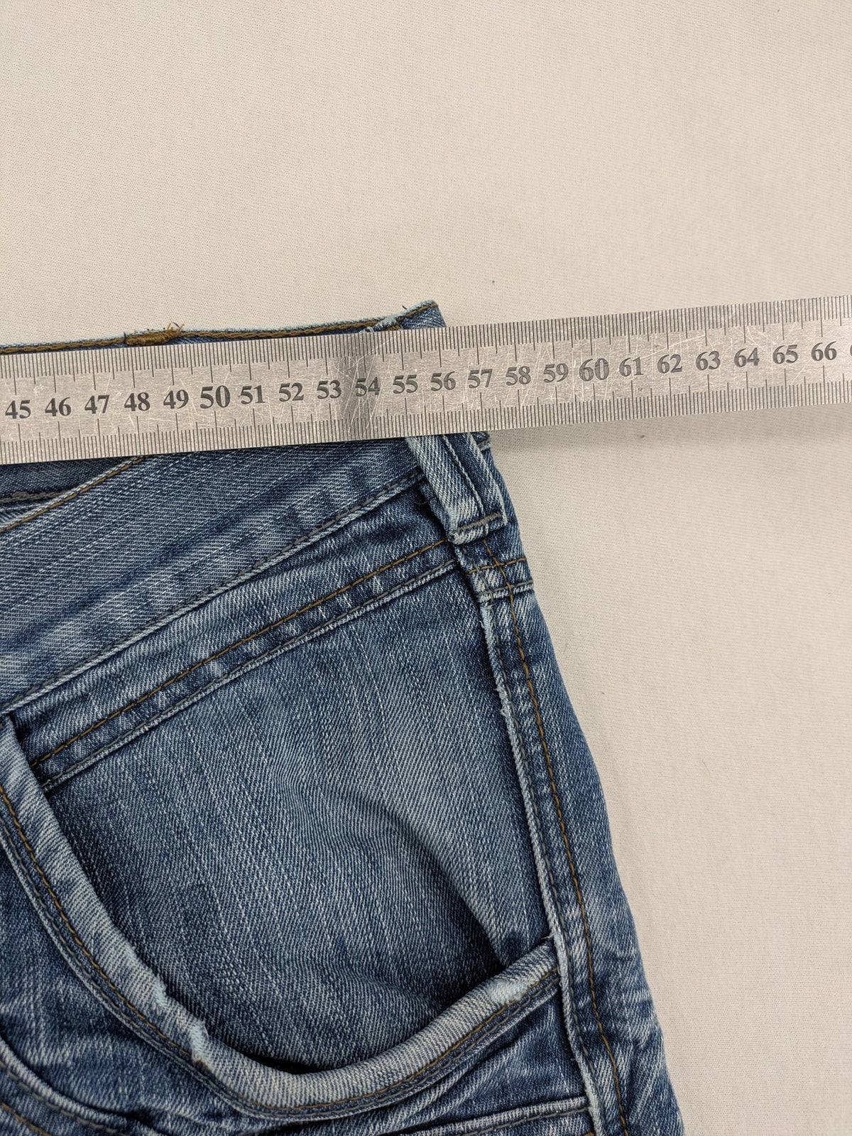 Premium Denim blue straight leg jeans with biker knee inserts and five-pocket design.