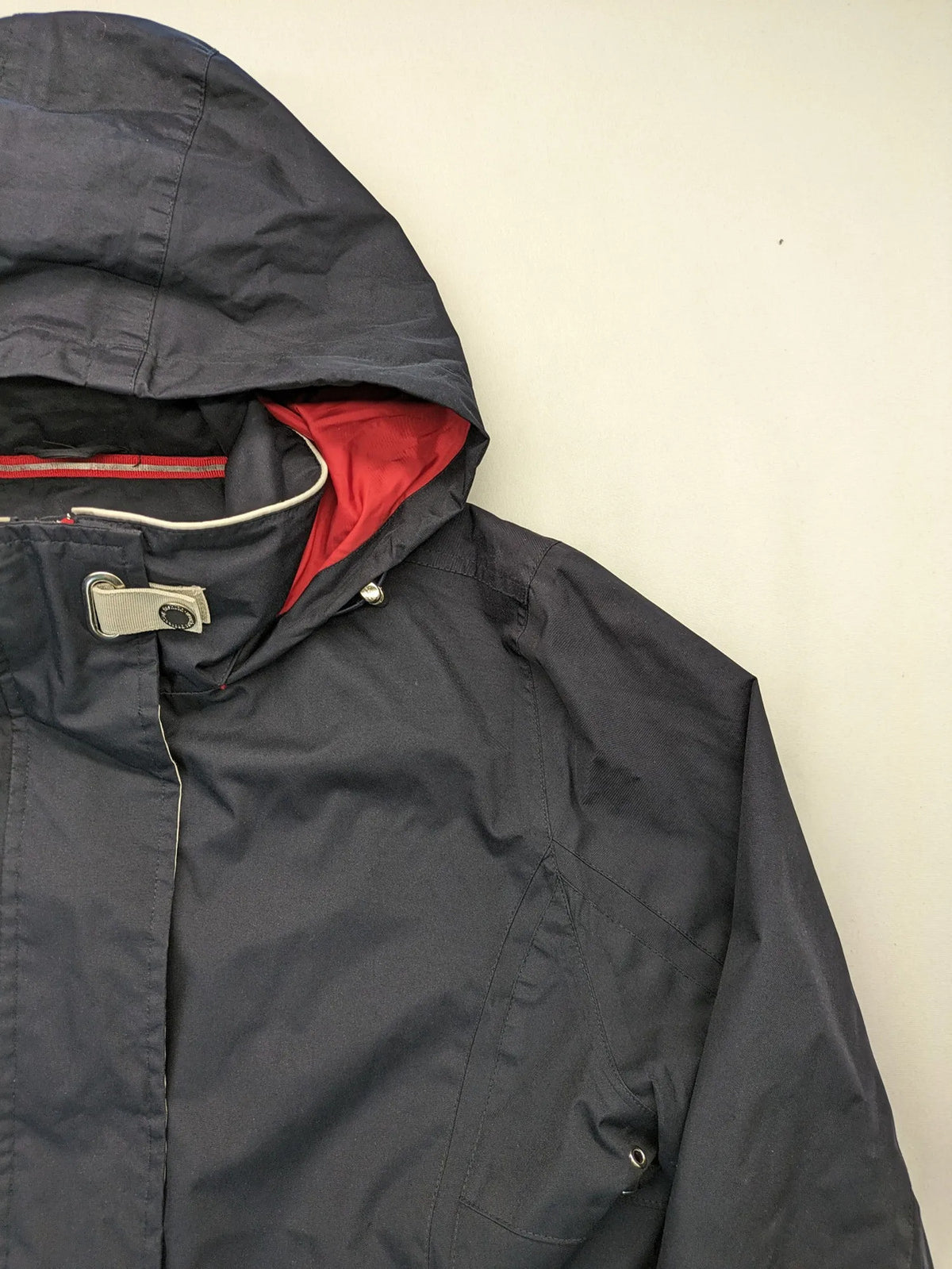 WPF grey outdoor jacket with red lining, zip closure, and hood.