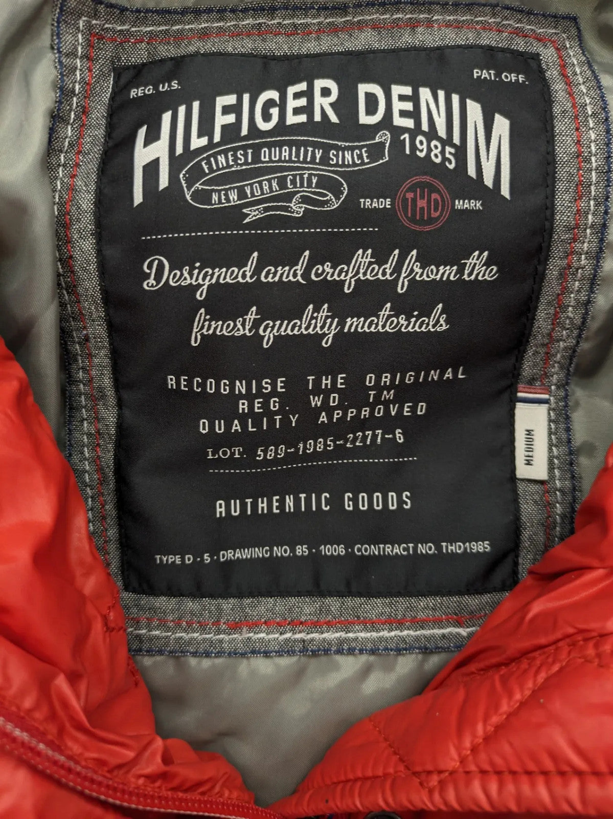 Hilfiger Denim red down jacket with quilted design, stand collar, and zip closure.