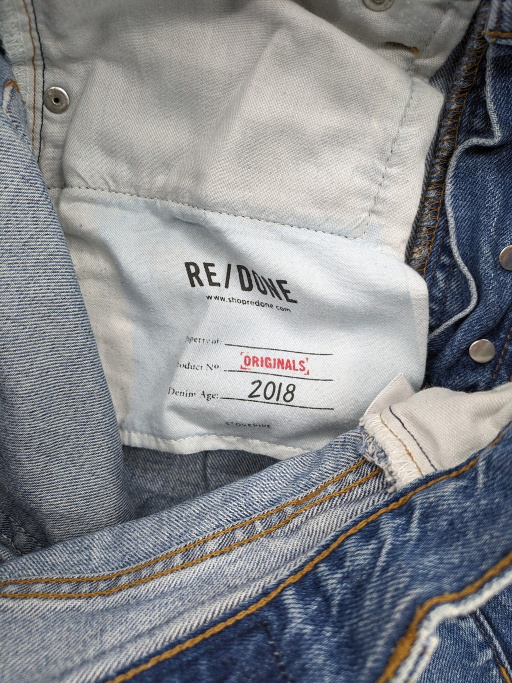 Re/Done blue straight jeans high rise with button fly and raw hem detail.