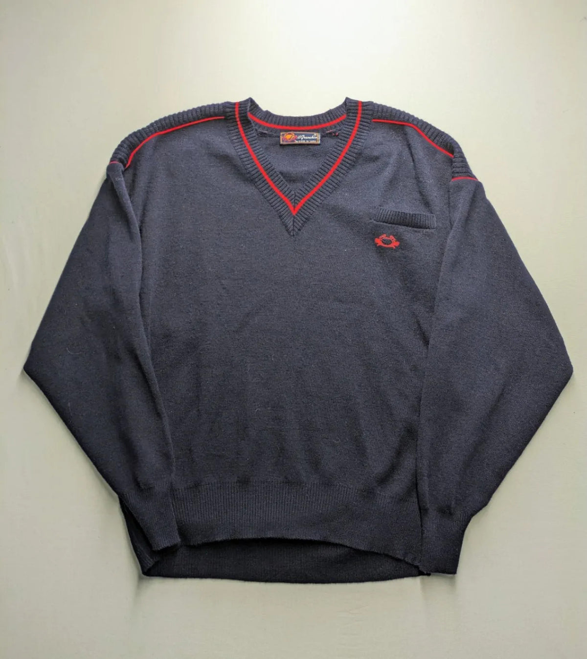 Il Granchio grey turtle neck jumper with red accents and embroidered crab logo.
