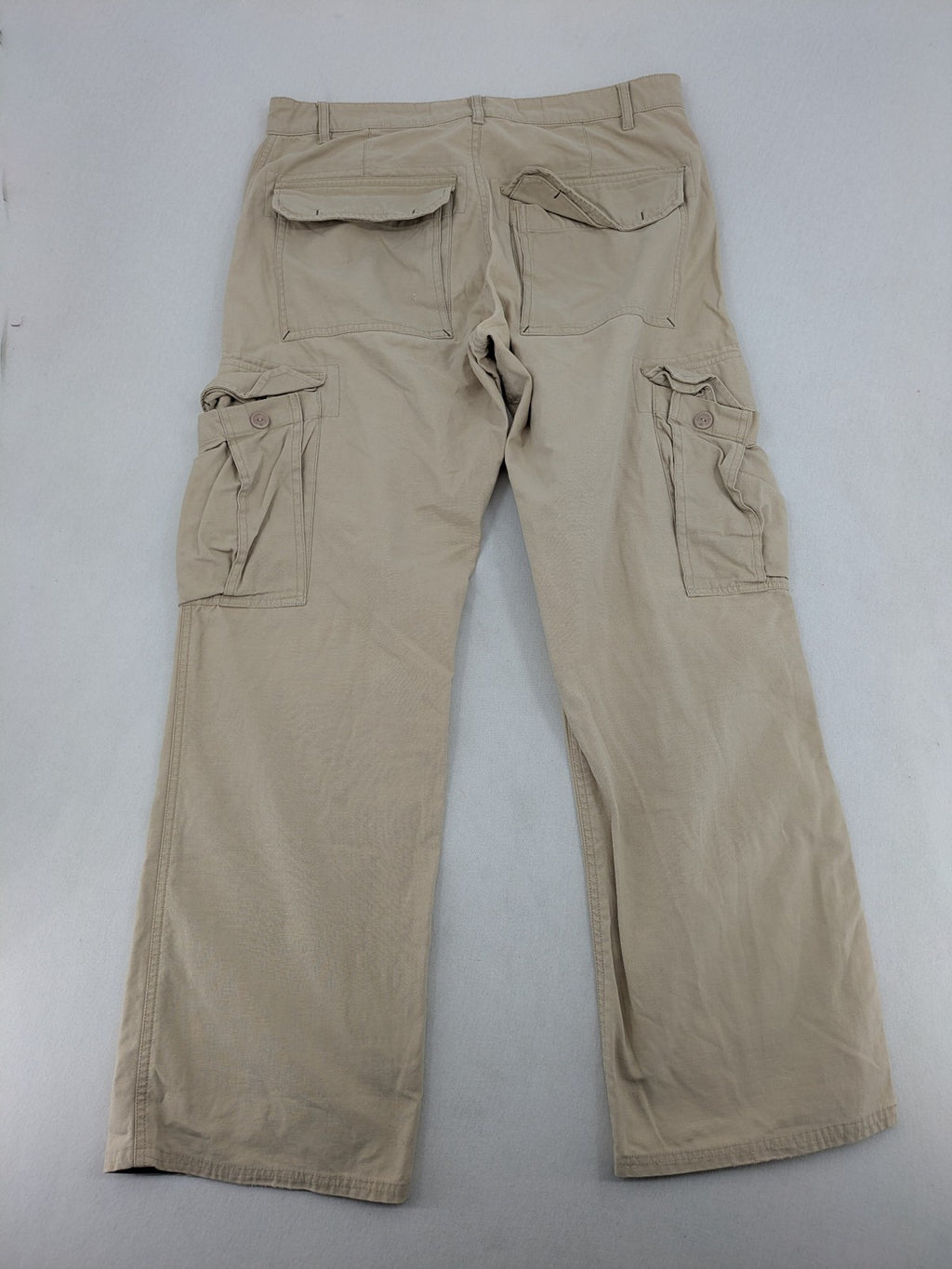 Cottonfield beige cargo pants with multiple pockets and button flaps.