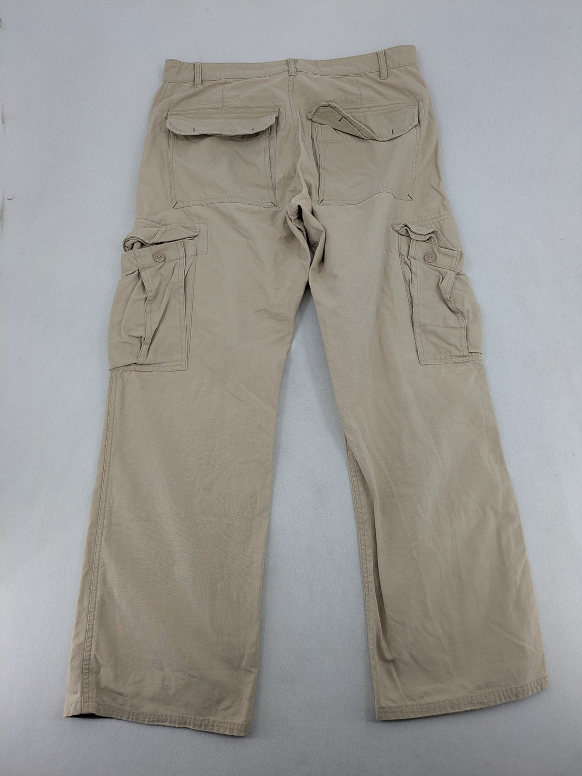 Cottonfield beige cargo pants with multiple pockets and button flaps.