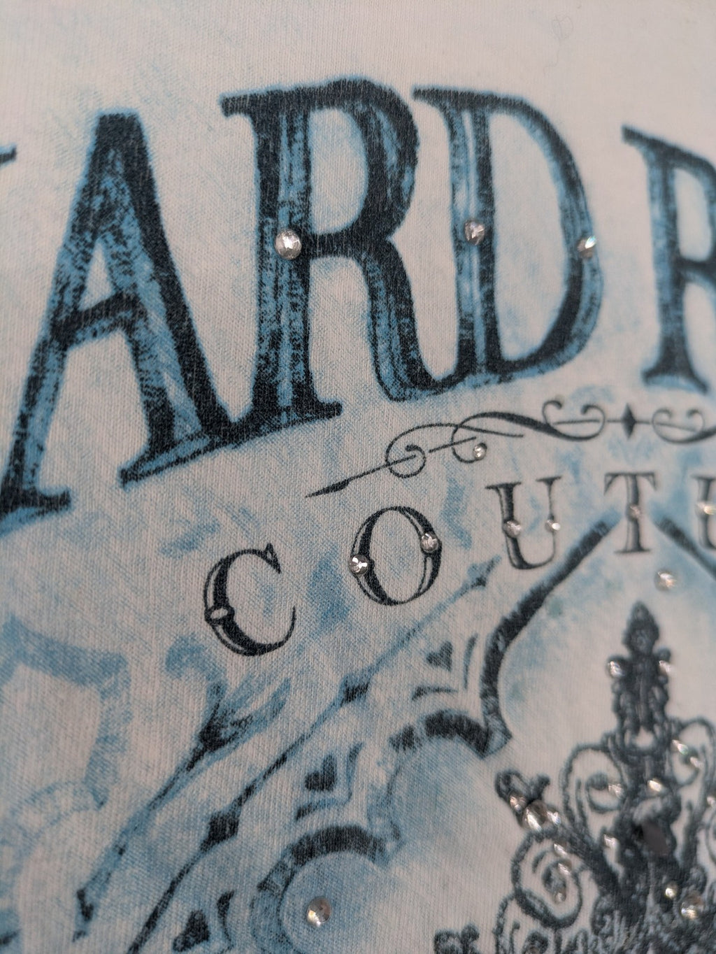 Hard Rock Cafe blue and white T-shirt with crown graphic and rhinestone accents.