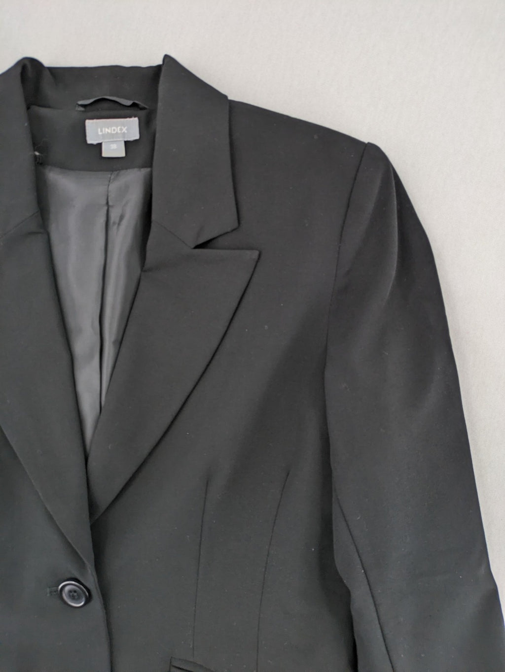 Lindex black blazer coat two-button design with subtle embroidery and tailored silhouette.