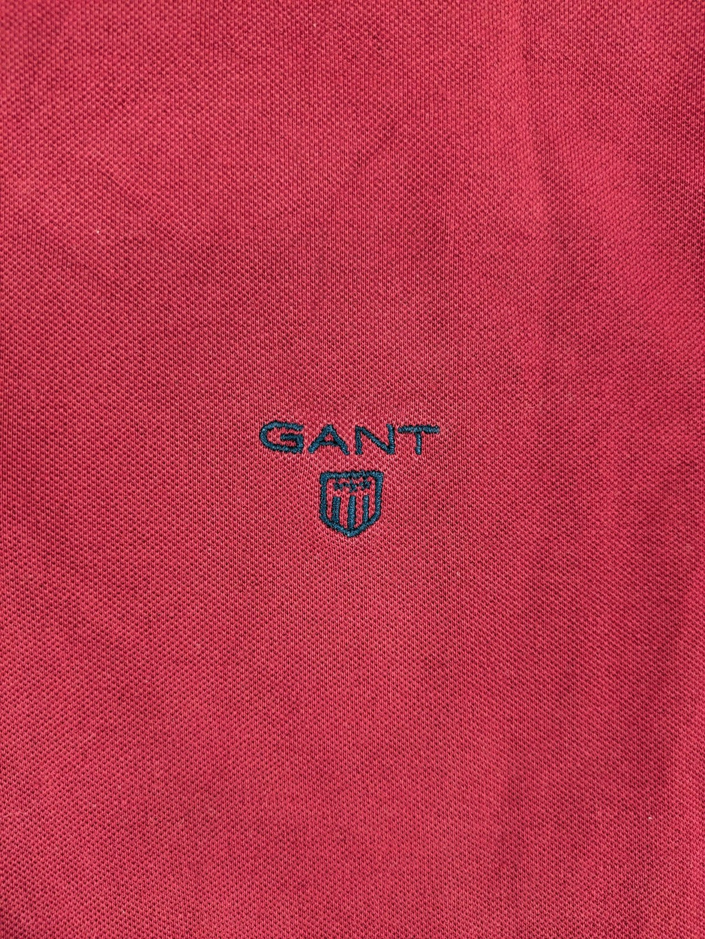 GANT burgundy polo shirt with embroidered shield logo and contrasting navy collar details.