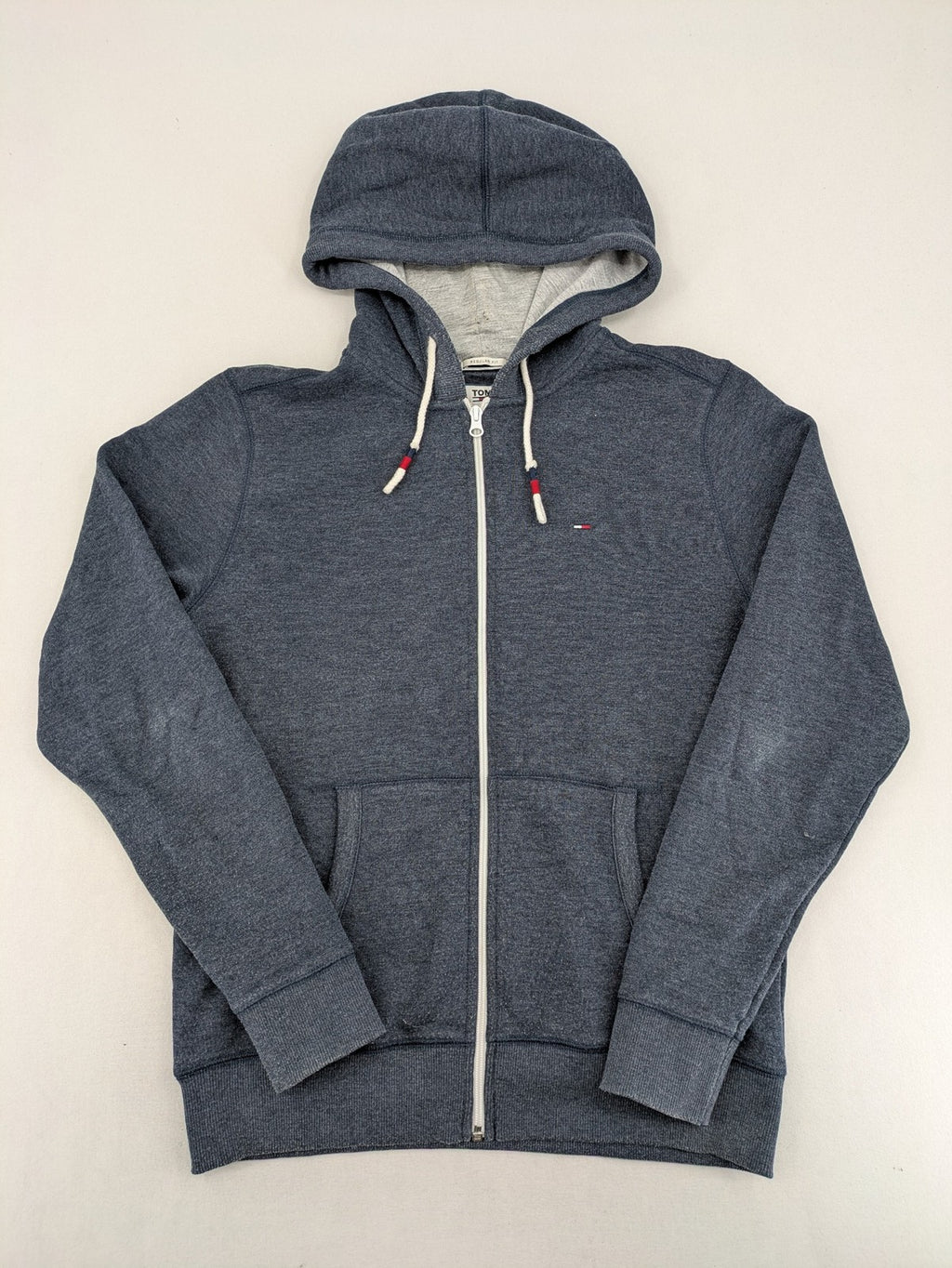 Tommy Jeans blue full zip hoodie with logo, adjustable hood, and kangaroo pockets.