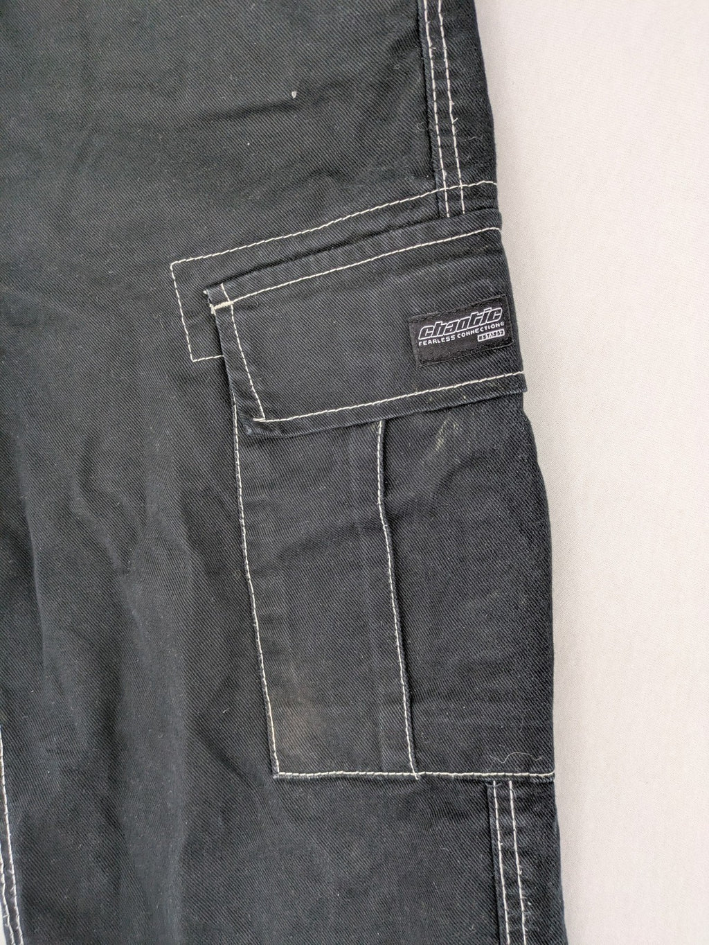 FSBN black baggy cargo pants with white contrast stitching and multiple pockets.