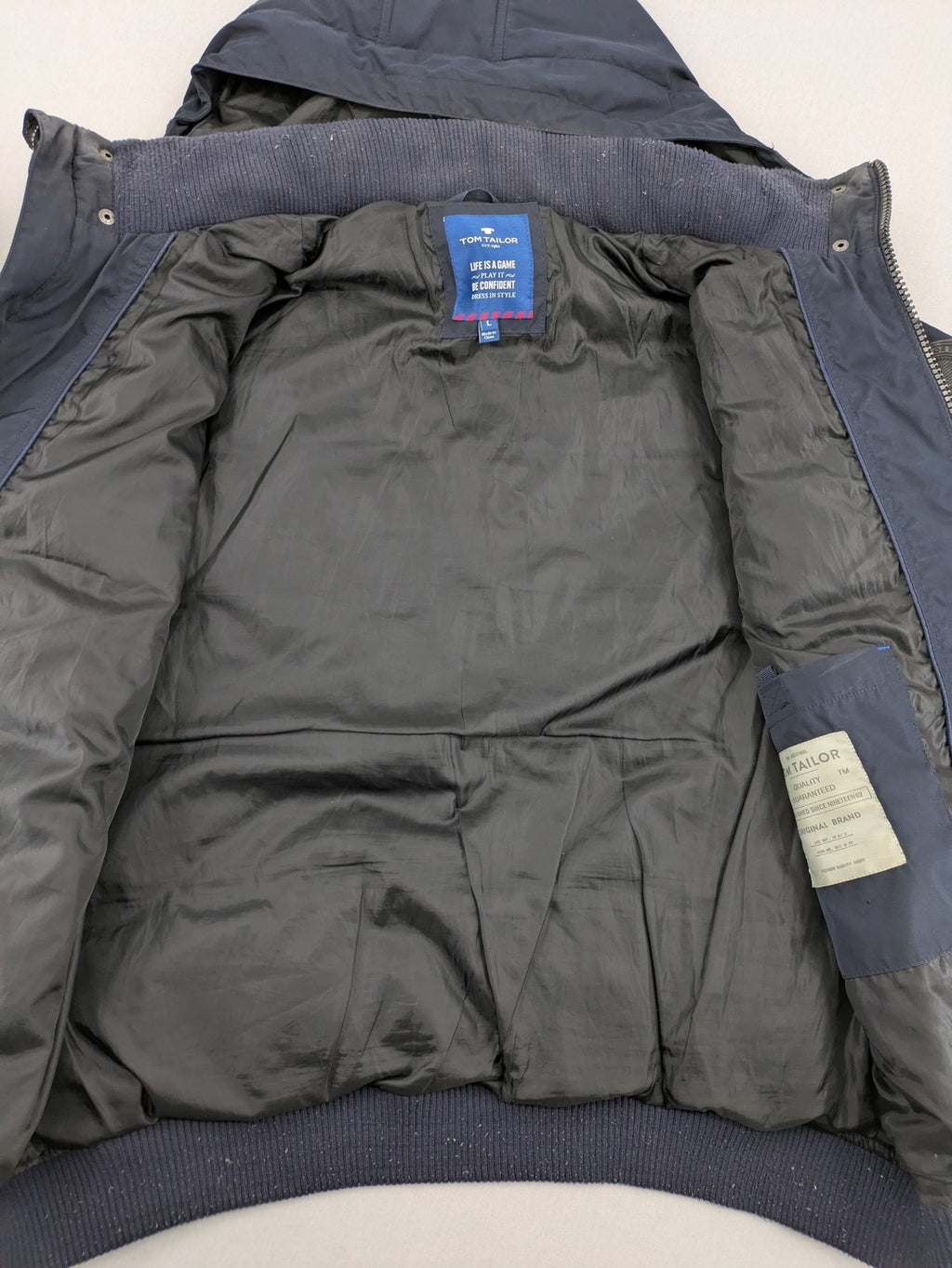 Tom Tailor navy puffer jacket with quilted design and adjustable hood, featuring multiple pockets.