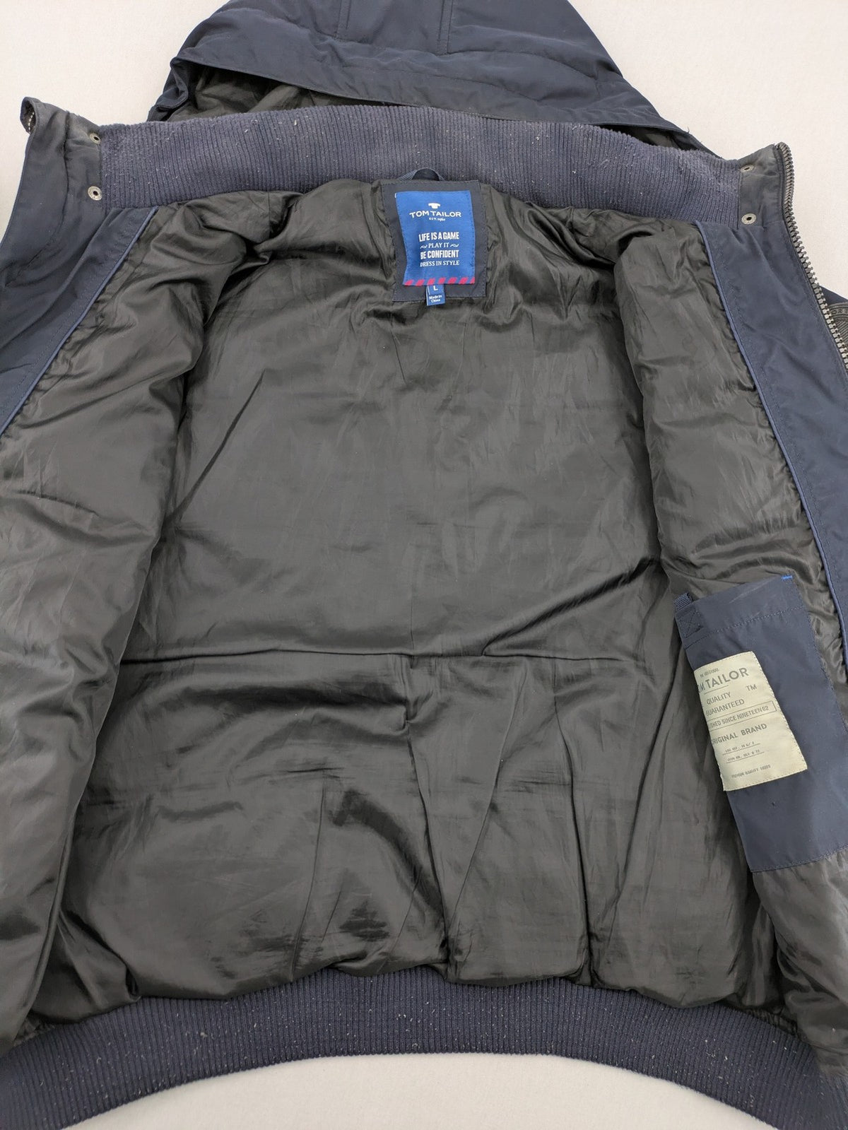 Tom Tailor navy puffer jacket with quilted design and adjustable hood, featuring multiple pockets.