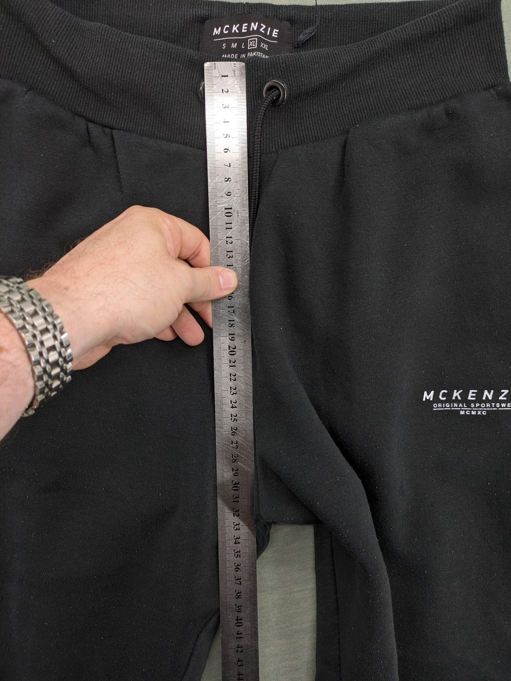 McKenzie black joggers with white logo, tapered fit, and ribbed ankle cuffs.
