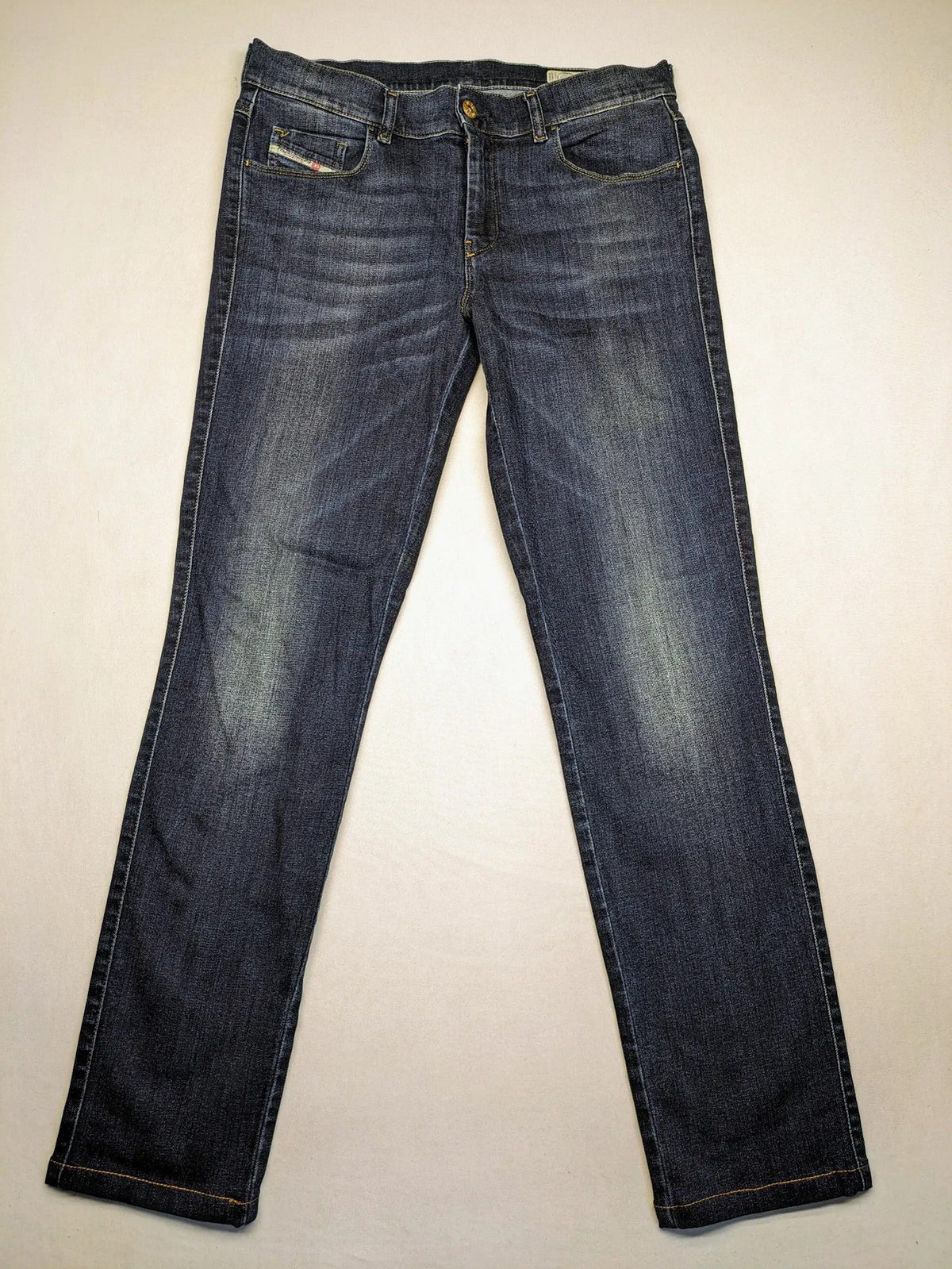 Diesel blue straight jeans with regular waist, dark wash, and stretch material.