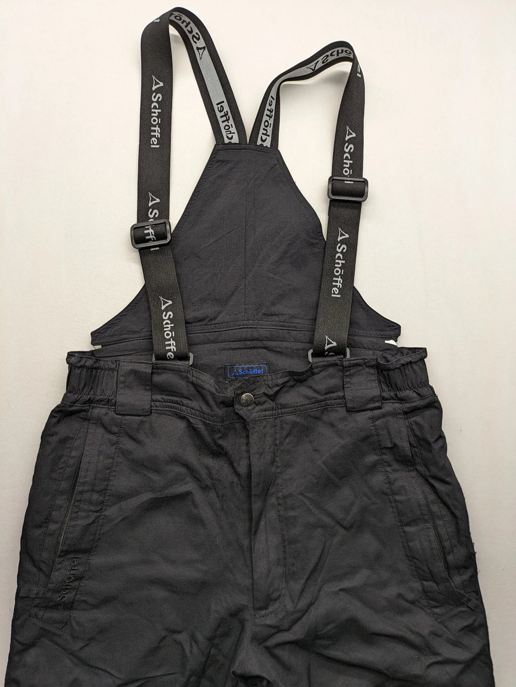 Schoffel black ski pants with adjustable straps, zip pockets, and snow gaiters.