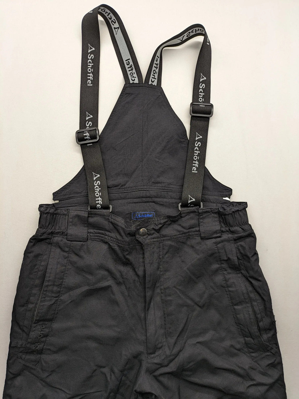 Schoffel black ski pants with adjustable straps, zip pockets, and snow gaiters.