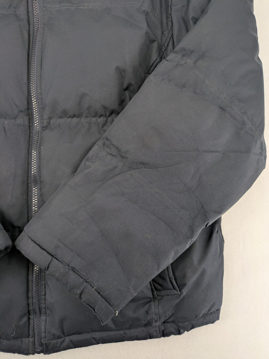 Identic black puffer jacket with quilted design and fleece-lined high collar.