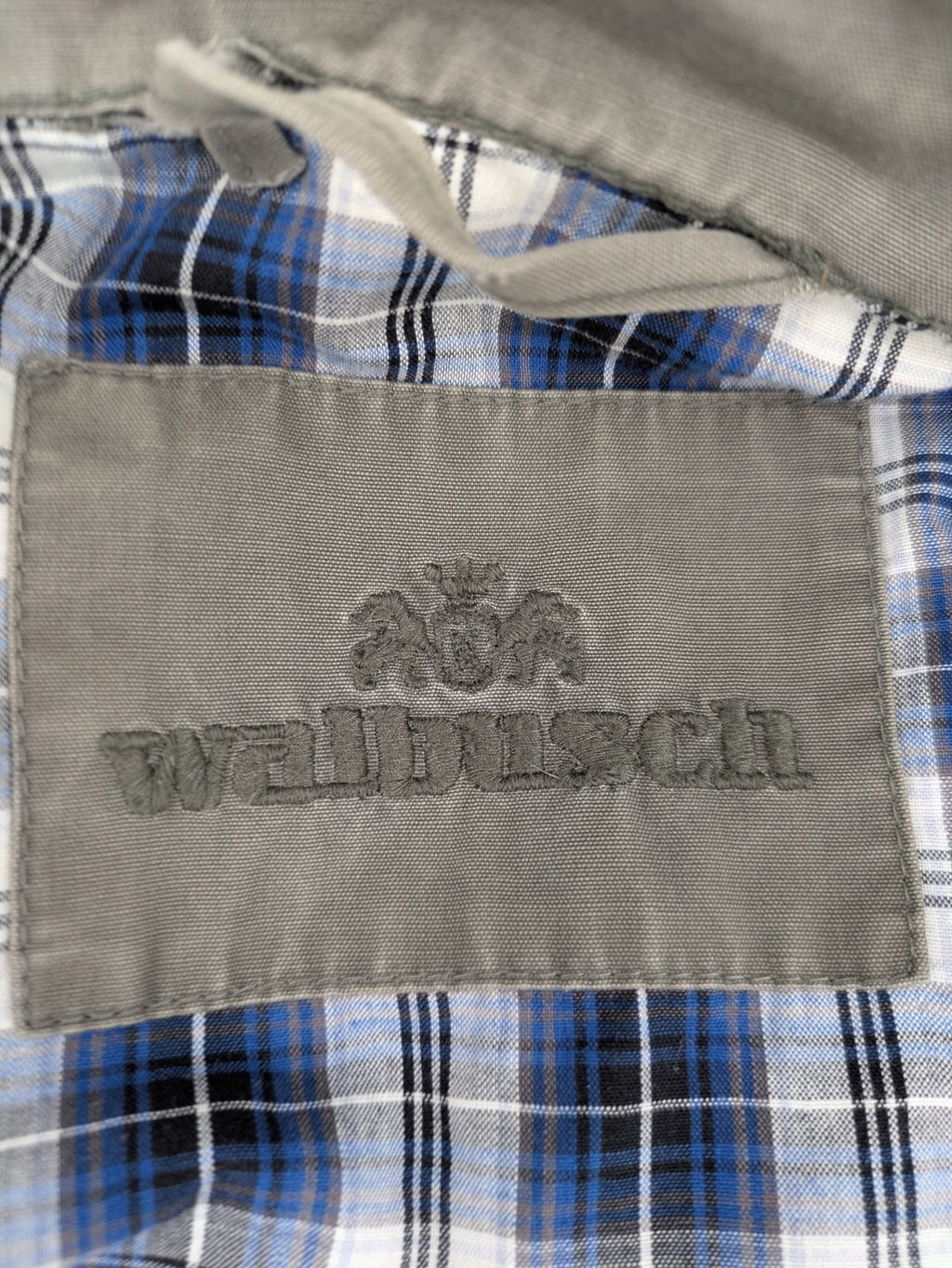 Walbusch khaki military jacket with checkered blue-white lining and multiple pockets.