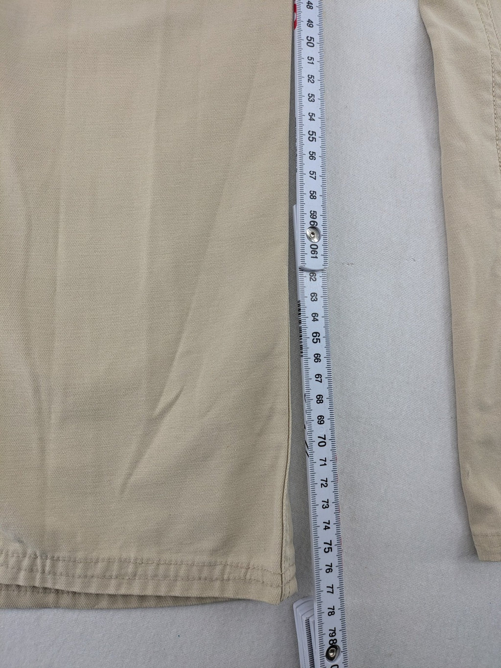 Cottonfield beige cargo pants with multiple pockets and button flaps.