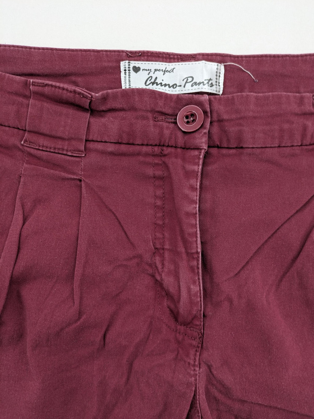 BPC Bonprix burgundy chino pants with front pleats and floral pocket lining.