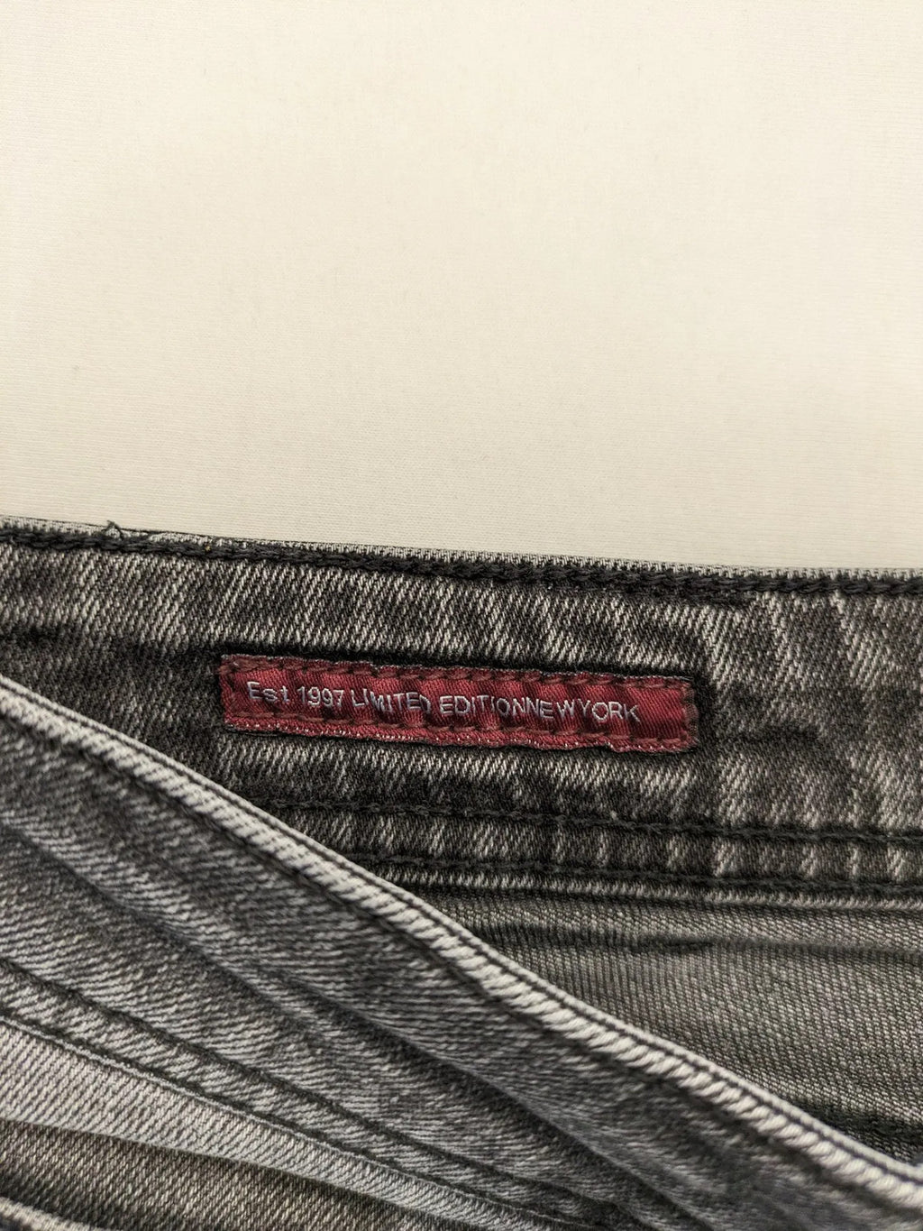 Denim grey straight jeans 5-pocket design with subtle brand details and zipper closure.