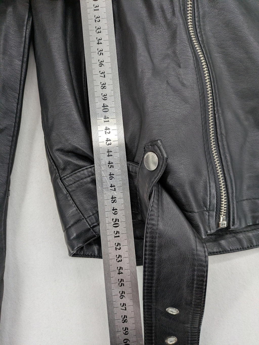 House Brand black biker jacket with hood, asymmetrical zipper, and belt detail.