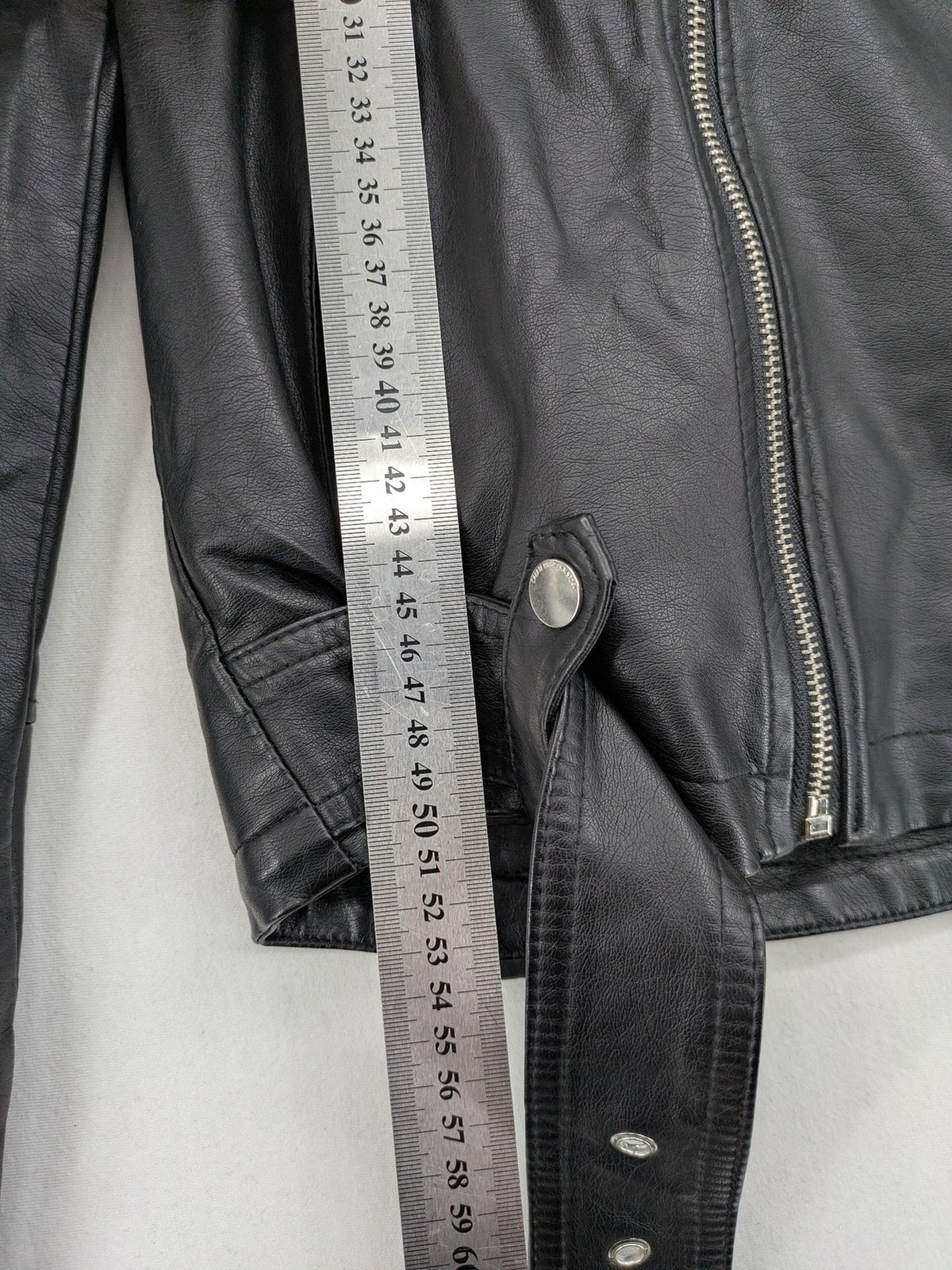 House Brand black biker jacket with hood, asymmetrical zipper, and belt detail.