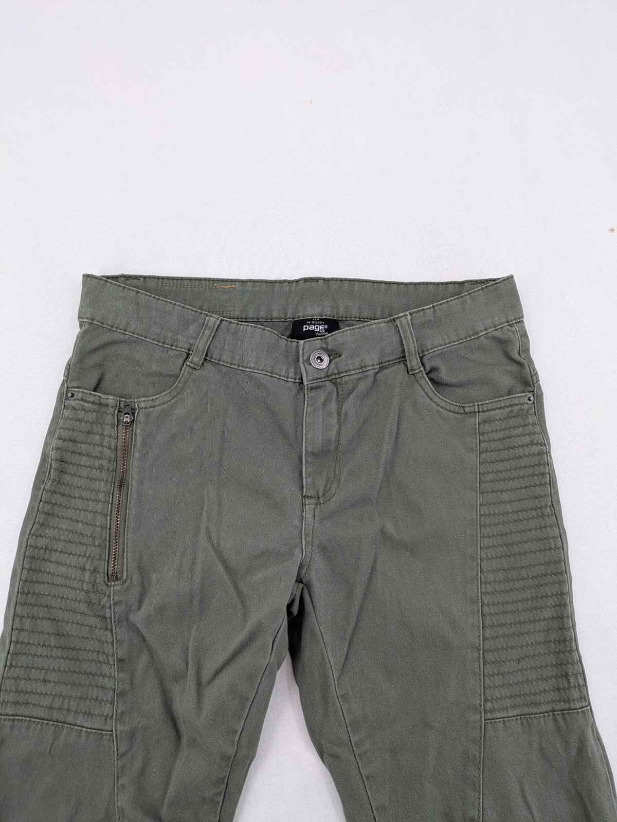 Page One Young khaki motorcycle pants with stitched panels and decorative zipper details.
