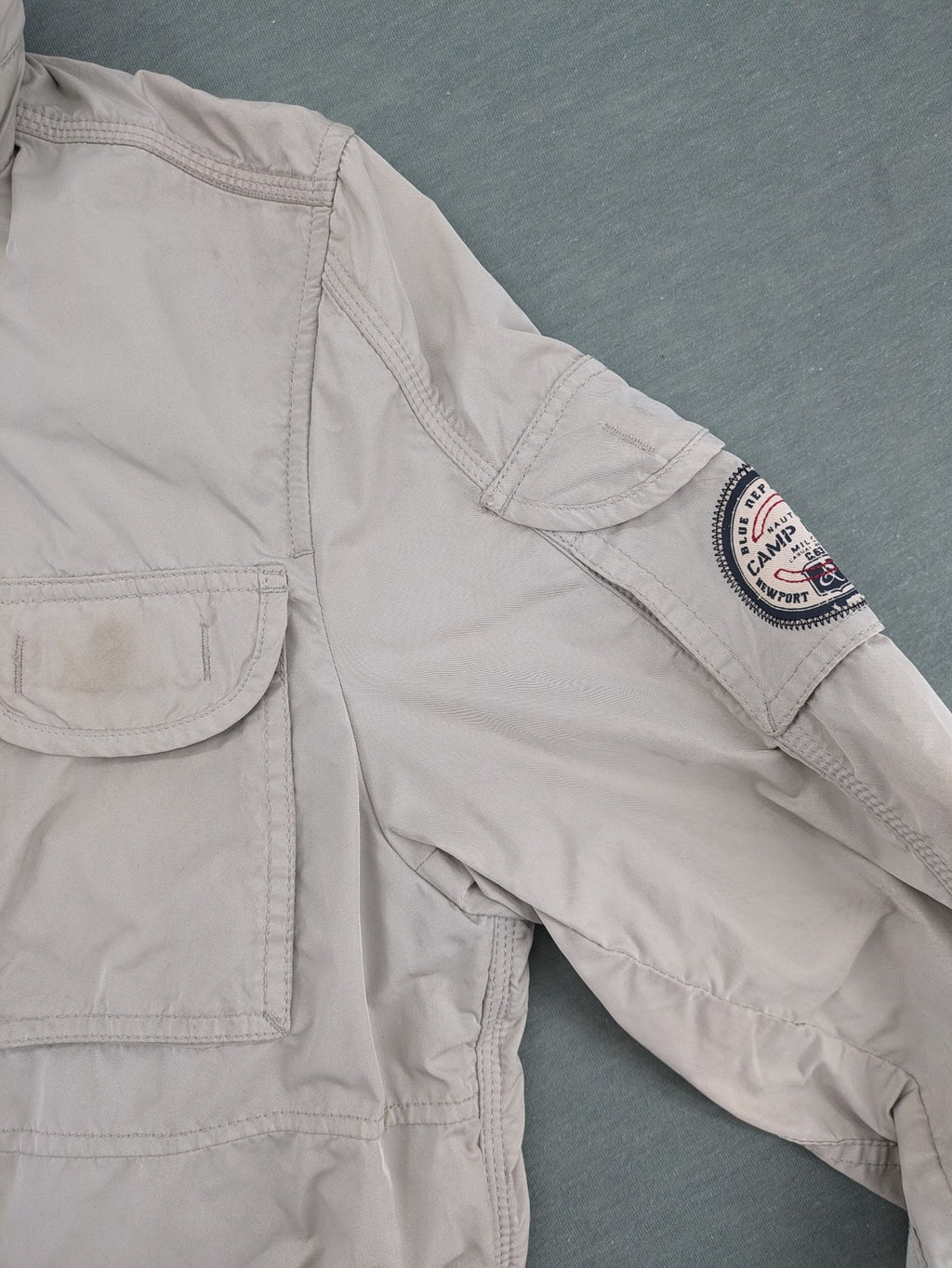 Camp David beige field jacket with logo patches, standing collar, and multiple pockets.
