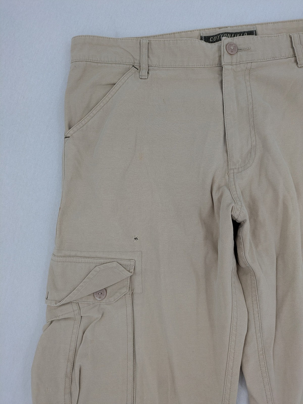 Cottonfield beige cargo pants with multiple pockets and button flaps.