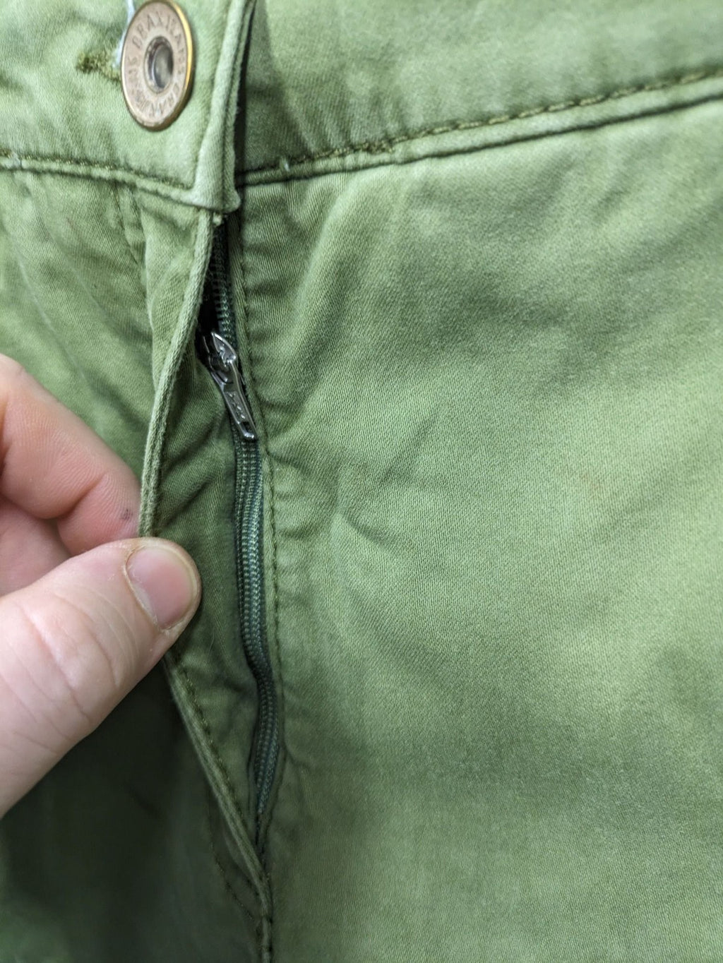 BRAX khaki pants classic five-pocket style with logo patch and zip button closure.