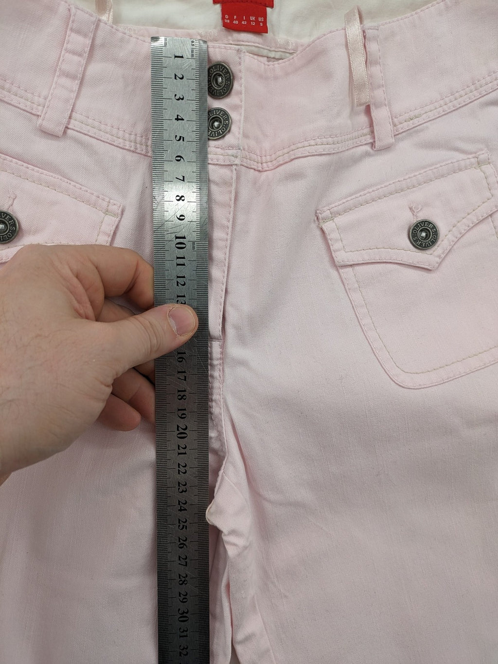 s.Oliver green bootcut pants with front pockets and button details, made of cotton-elastane blend.
