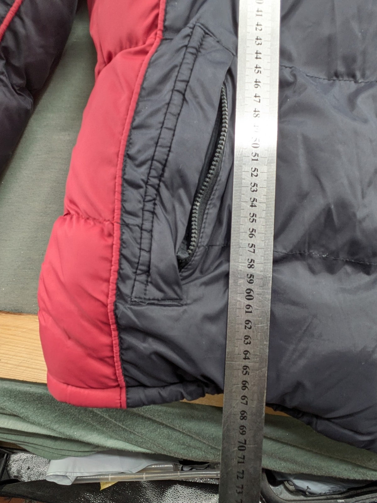 Puffer grey and red jacket with fleece lining, front zipper, and side pockets.