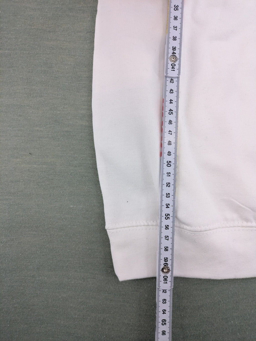 KATSEYE white zip-through hoodie with black silhouette graphic and logo, classic pullover style.