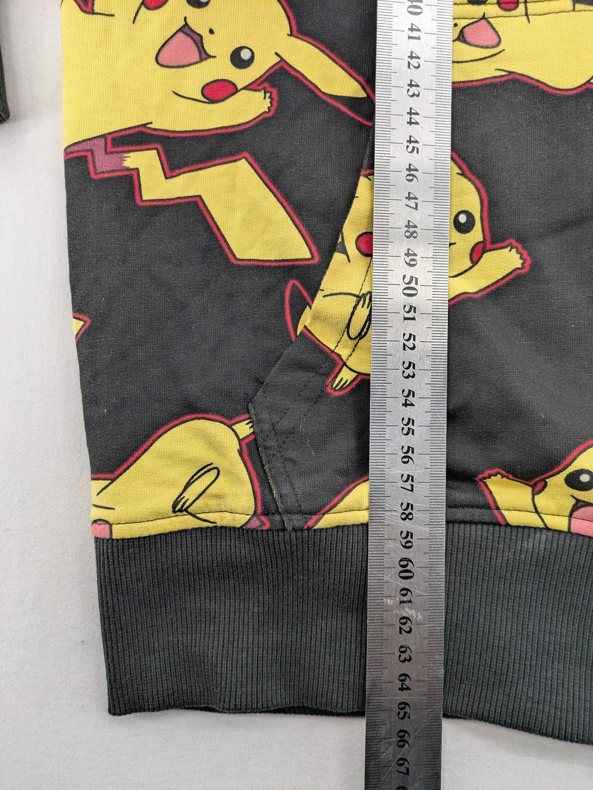 Herren black zip-through hoodie with vibrant Pikachu allover print and yellow lining.