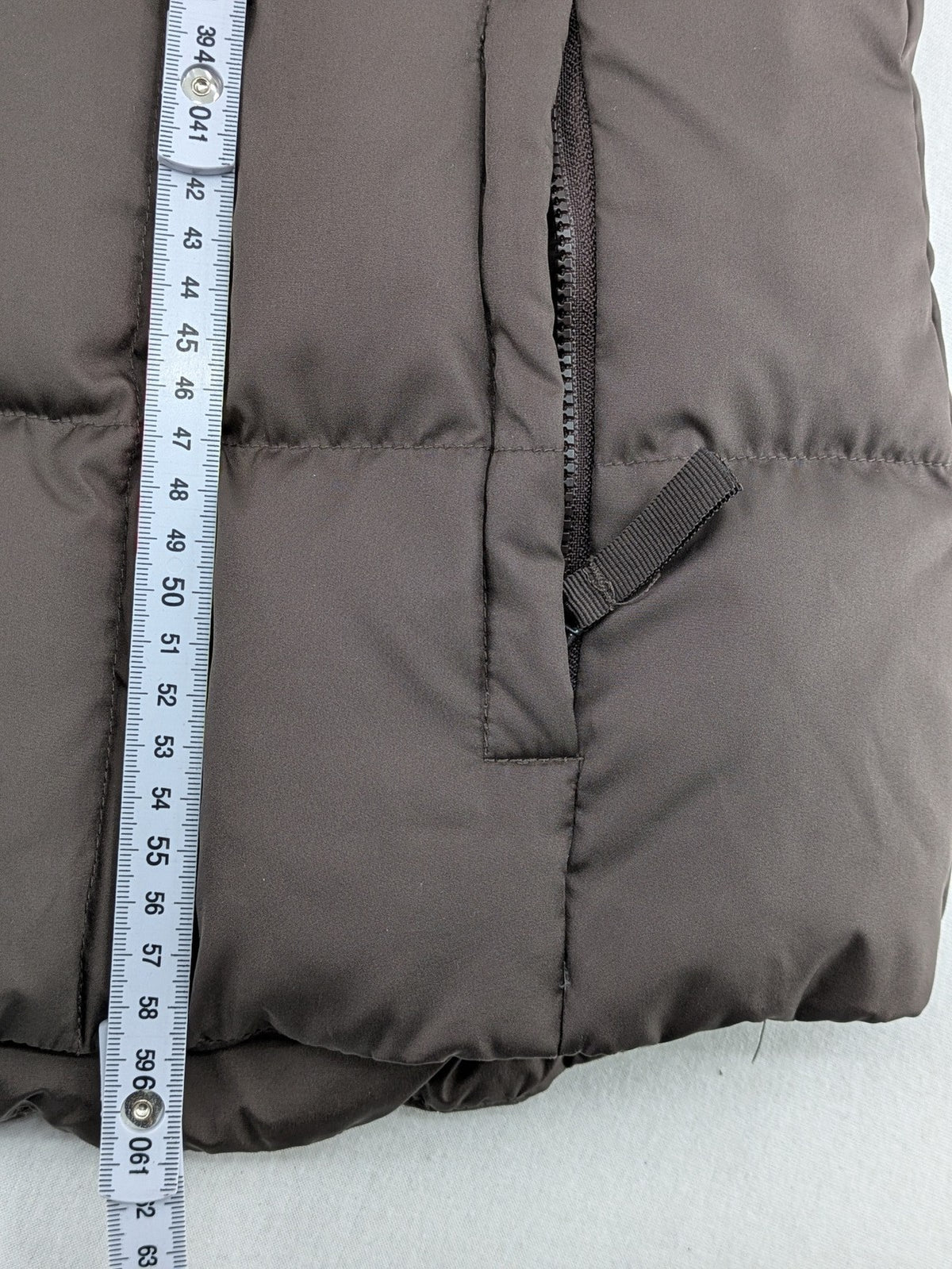 Esprit brown puffer vest with high ribbed collar and zip button closure.