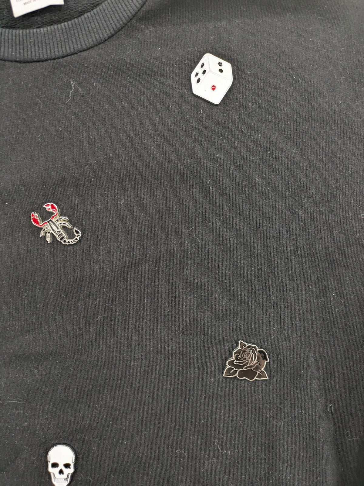 Zara grey turtle neck jumper with skull, scorpion, flame, and eagle embellishments.