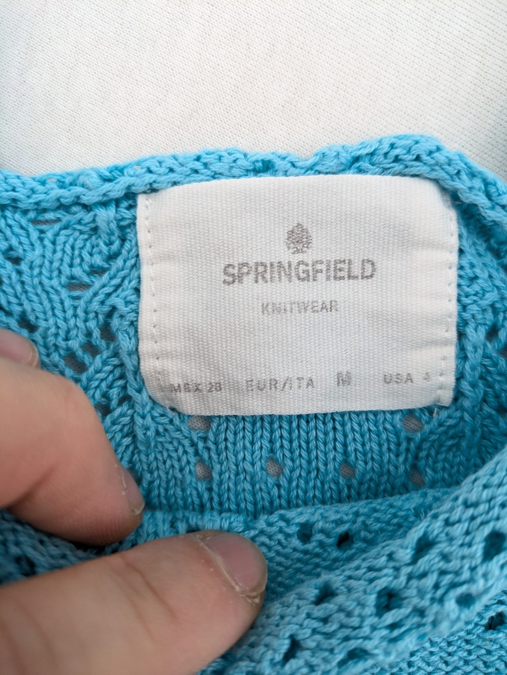 Springfield blue knit top with ruffled straps, peplum hem, and lace embroidery.