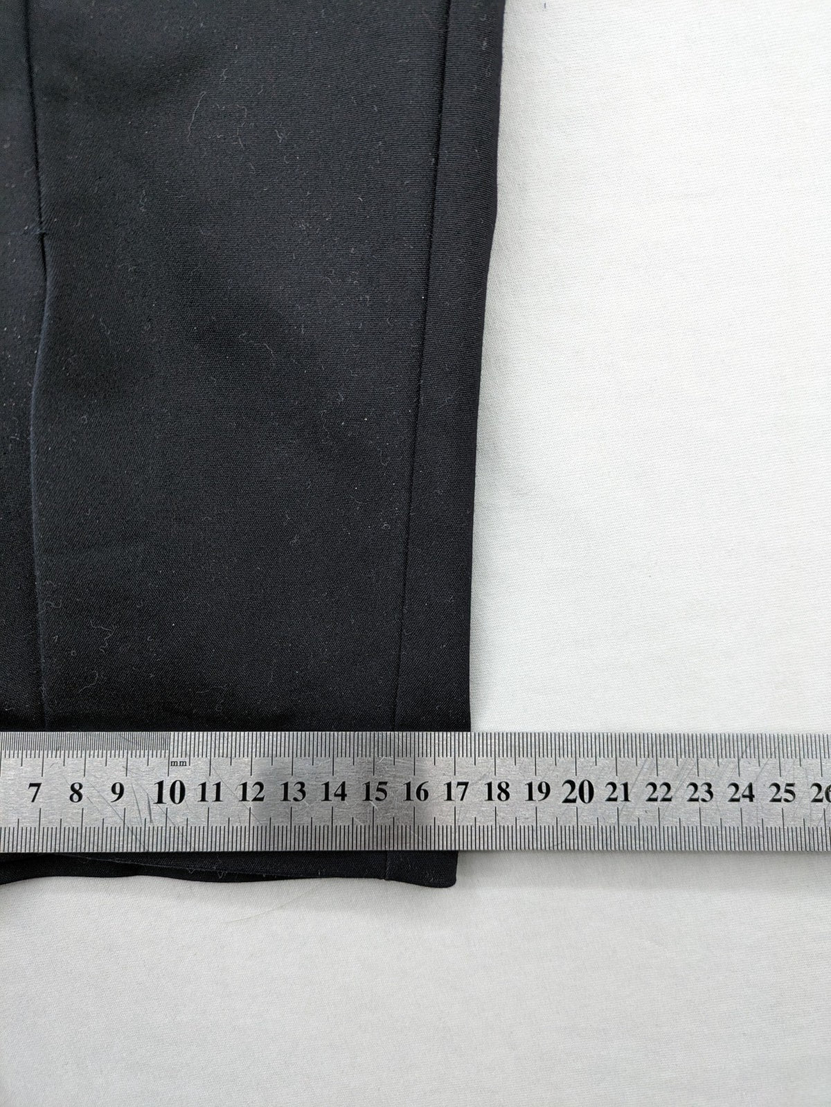 Zara black pants with front creases, subtle slit hem, and buttoned back pocket.