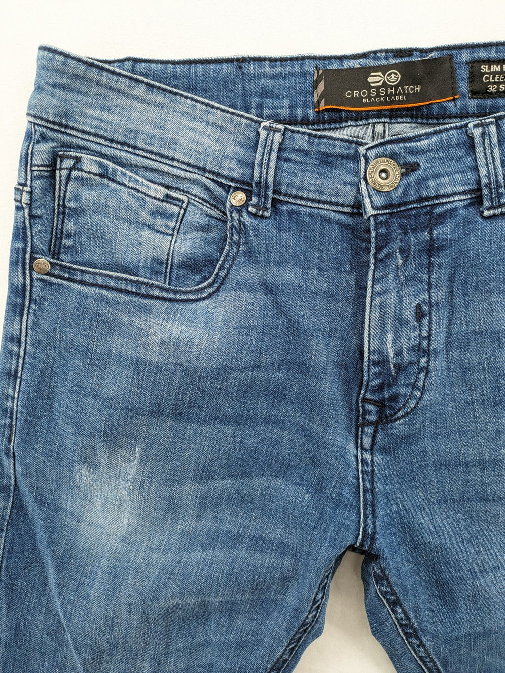 Crosshatch blue slim fit jeans with faded wash and logo patch on back pocket.
