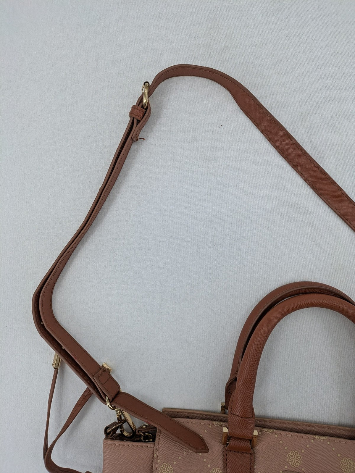 Catwalk gold handbag with pink and brown monogram pattern, adjustable shoulder strap.