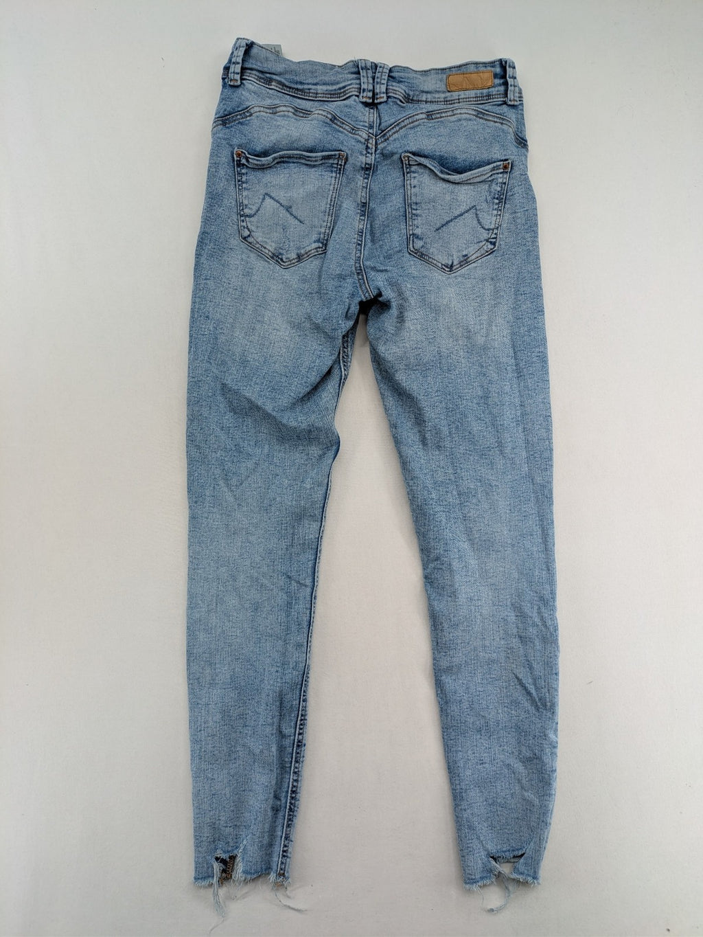 Clockhouse blue skinny jeans with distressed details and frayed hem, mid-rise fit.